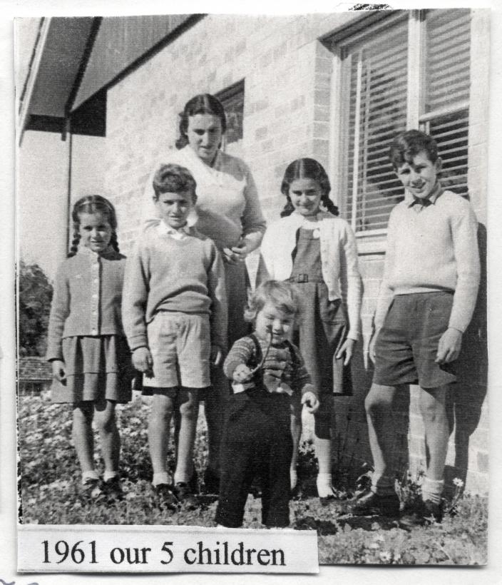 Illona and her five children standing by their home 